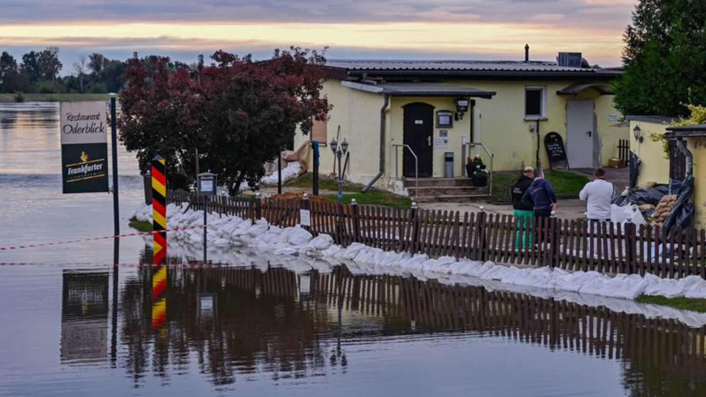 Überflutungen: Hochwasser: Einsatzkräfte mit Booten bergen Treibgut