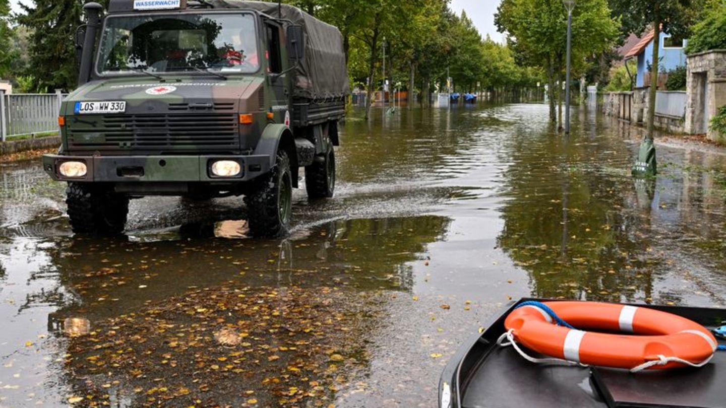 Überflutungen: Wasserwacht bringt Bewohner durch überflutetes Gebiet